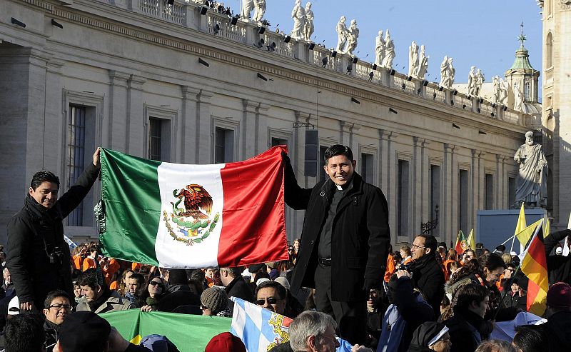 Dos sacerdotes mexicanos sujetan la bandera de su país en la plaza de San Pedro, a donde han llegado fieles de todo el mundo.