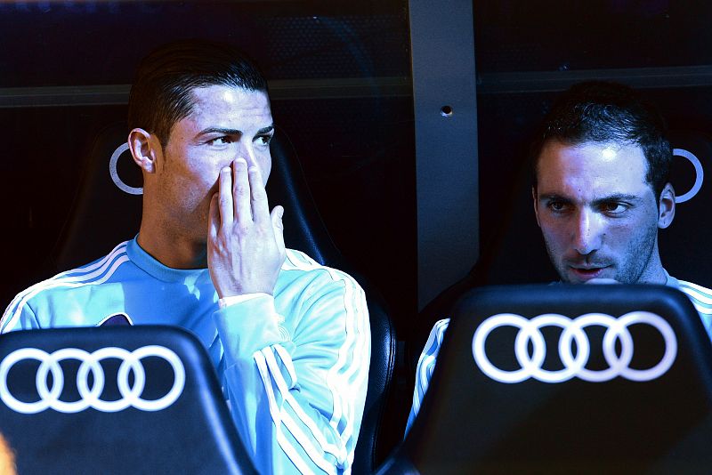 El jugador del Real Madrid Cristiano Ronaldo charla con Gonzalo Higuain en el banquillo antes de salir al campo.