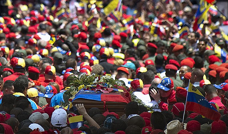 La 'marea roja' acompaña por las calles de Caracas al coche fúnebre con el ataúd de Hugo Chávez, cubierto por la bandera venezolana