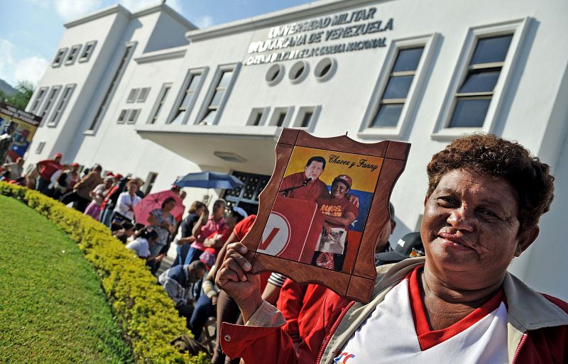 Una simpatizante chavista posa con una foto suya junto al fallecido presidente de Venezuela