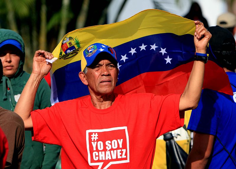 Uno de los chavistas que ha acudido a la capilla ardiente del presidente, con una camiseta con el lema "Yo soy Chávez" y ondeando la bandera venezolana