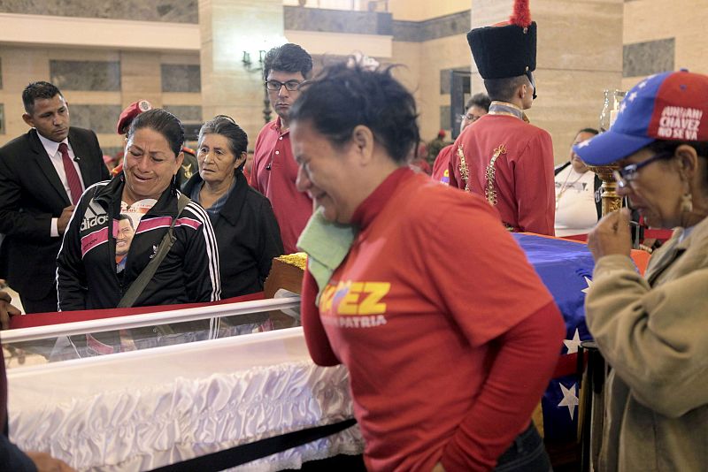 Varios seguidores de Hugo Chávez lloran su muerte ante el féretro en la capilla ardiente de la Academia Militar de Caracas