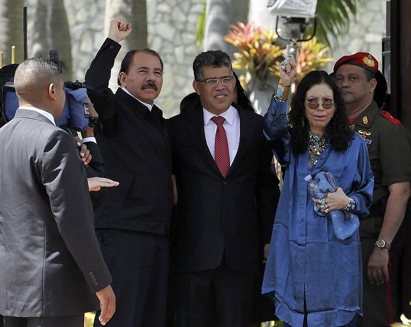 El presidente de Nicaragua, Daniel Ortega, alza el puño en su saludo antes de entrar al funeral de Chávez, acompañado por el ministro de asuntos exteriores de Venezuela, Elias Jaua