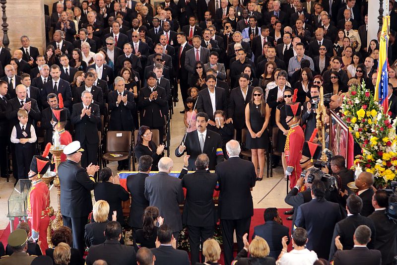 El vicepresidente Nicolás Maduro impone la espada de Bolívar sobre el féretro de Hugo Chávez envuelto, en la bandera venezolana, en un momento del funeral de Estado en la Academia Militar de Caracas