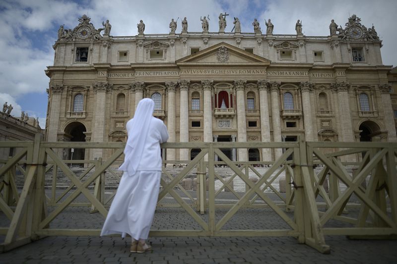 Una religiosa reza observando desde el exterior en la plaza de San Pedro del Vaticano