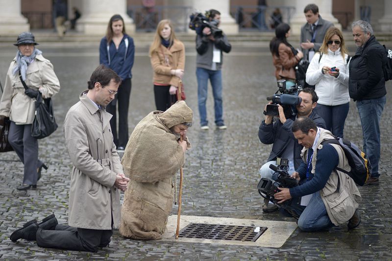 Dos fieles de "dos mundos diferentes" se unen para rezar arrodillados en la plaza de San Pedro del Vaticano