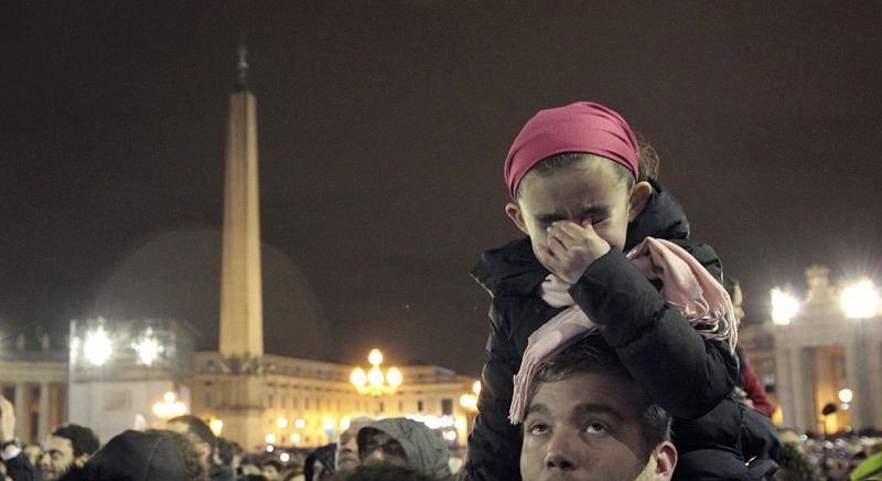 Una niña llora entre la multitud presente en la plaza de San Pedro