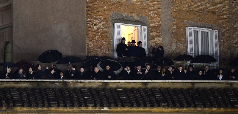 Algunos ciudadanos observan desde un balcón aledaño a la plaza de San Pedro