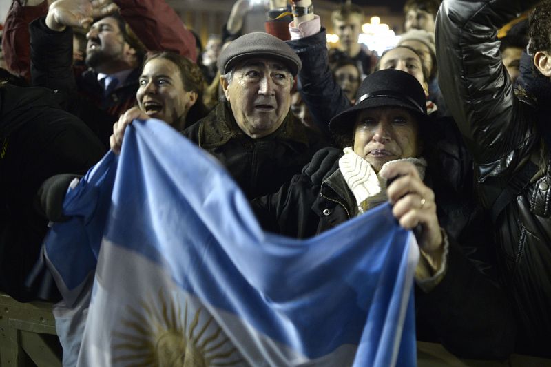 Una pareja con la bandera argentina celebra la elección del nuevo papa, Francisco