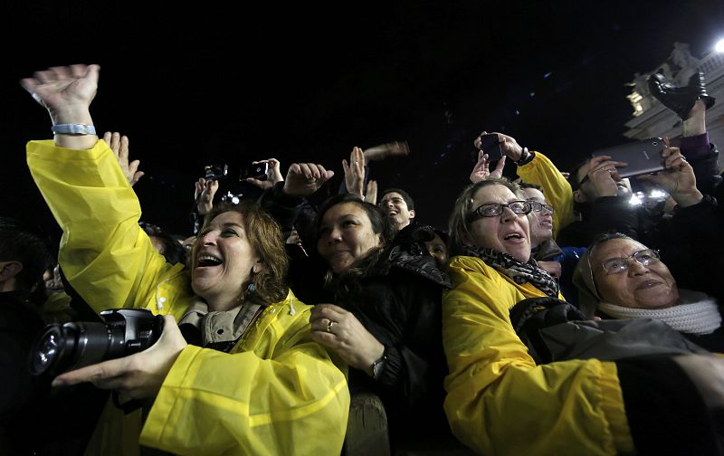 Los feligreses que han acudido en masa a la plaza de San Pedro saludan al nuevo papa Francisco, asomado al balcón de la Basílica