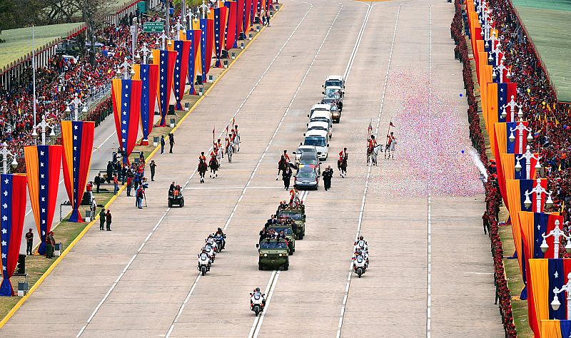 El coche fúnebre con el féretro de Hugo Chávez avanza hacia el Cuartel de la Montaña custodiado por una comitiva y acompañado por la presencia de miles de venezolanos.