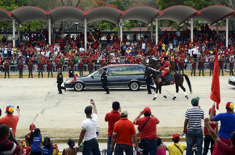 Los chavistas presentes en el recorrido saludan al coche fúnebre y captan el momento con cámaras y teléfonos