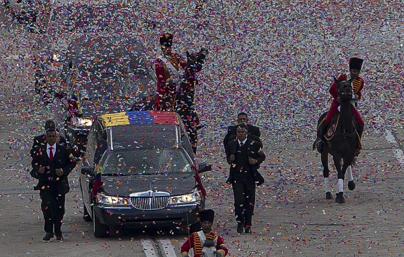 El coche fúnebre escoltado bajo el confeti en el recorrido desde la Academia Militar hacia el Cuartel de la Montaña