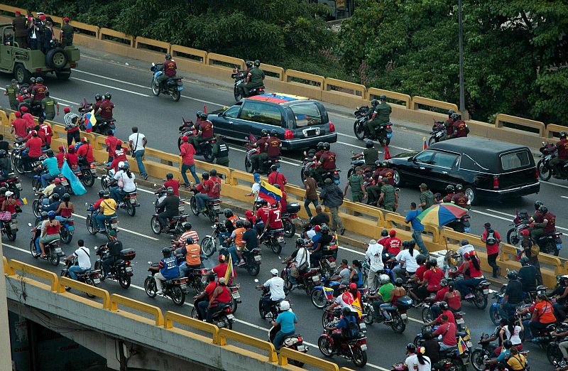 Algunos de los ciudadanos que han acompañado, andando o en sus vehículos, al féretro de Hugo Chávez en su recorrido hasta el Cuartel del Monte