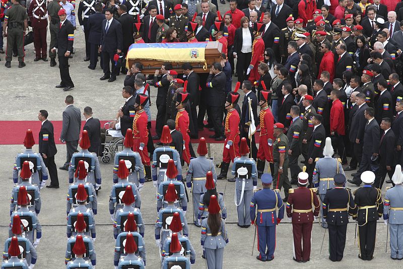 Varios hombres portan el féretro de Hugo Chávez