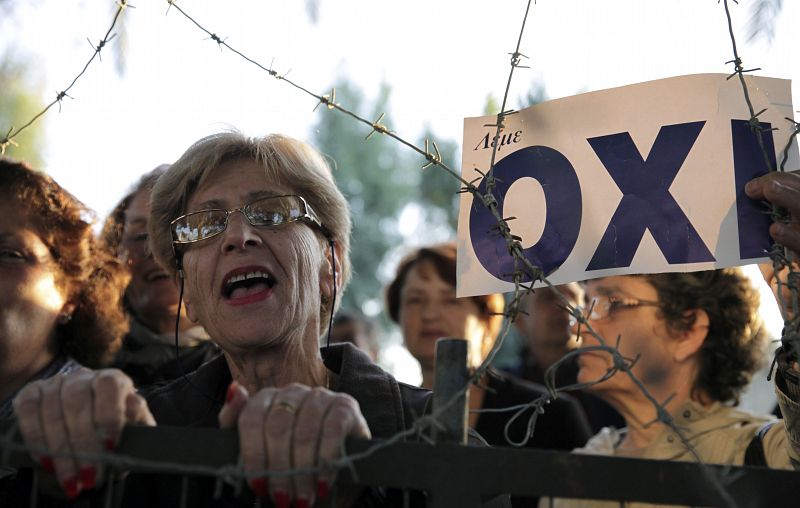 Una ciudadana chipriota protesta, entre alambres de espino, contra la votación sobre el rescate económico