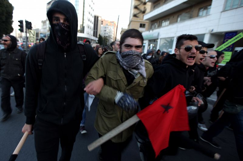 Algunos de los manifestantes se cubren los rostros en la protesta contra la propuesta de rescate financiero a Chipre, que ha sido rechazada por el Parlamento