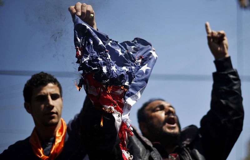 Una bandera estadounidense arde durante las protestas en Gaza con motivo de la visita del presidente Barack Obama