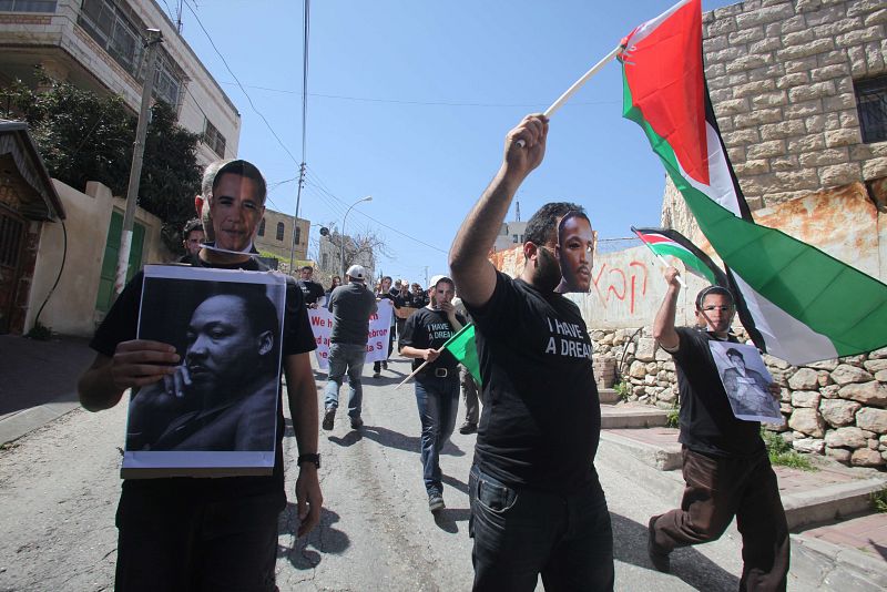 Palestinos con caretas de Barack Obama y Martin Luther King protestan por la visita del presidente de Estados Unidos a Israel