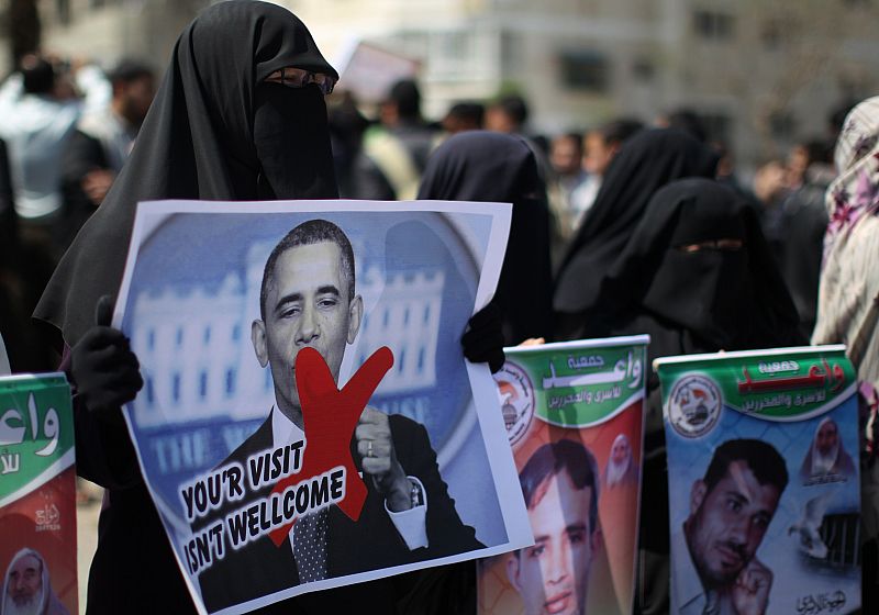 Familiares de presos palestinos sostienen carteles con el mensaje, en inglés, "su visita no es bienvenida"