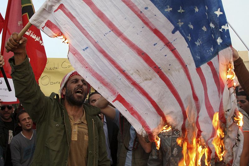 Manifestantes palestinos queman banderas estadounidenses en señal de protesta contra la visita del presidente Barack Obama