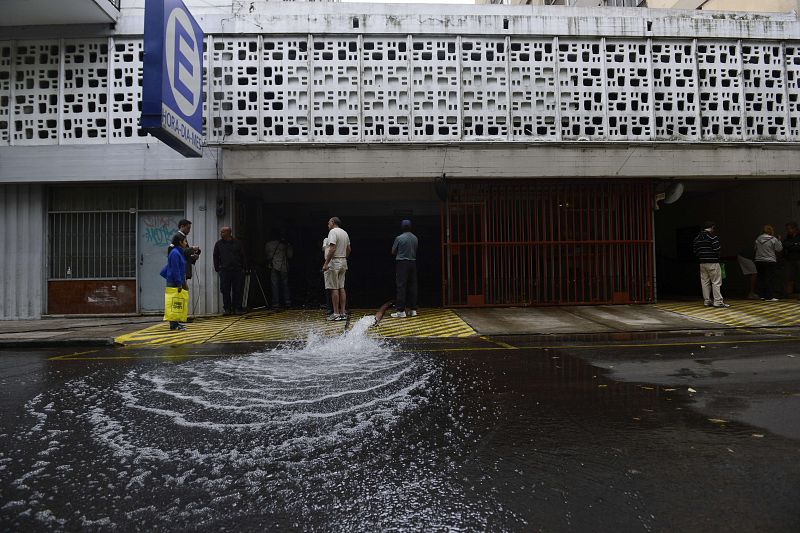 Unos ciudadanos evacúan agua de un edificio