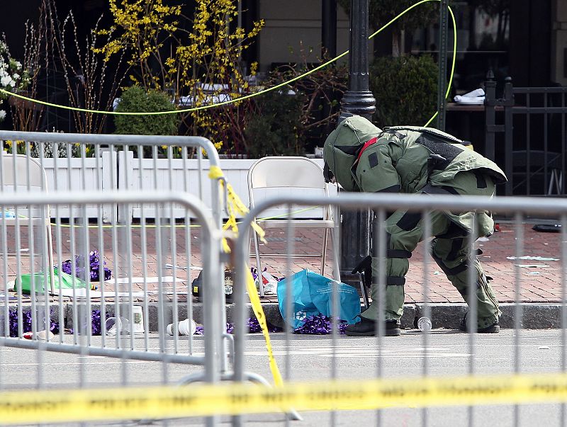 Un miembro del cuerpo de explosivos investiga un objeto sospechoso cerca de la plaza Kenmore de Boston