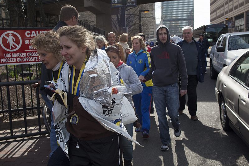 Un grupo de ciudadanos es evacuado de la zona donde se han producido las explosiones del maratón de Boston que ha acabado con la vida de al menos tres personas