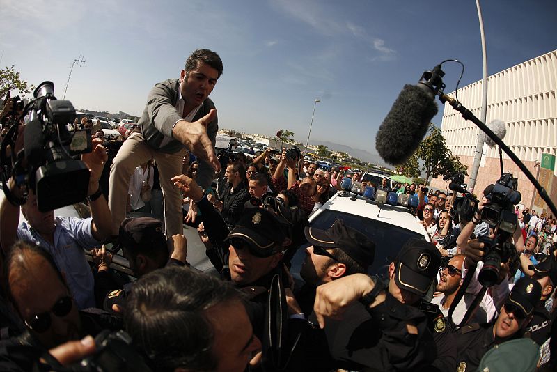 Spanish singer Pantoja's chauffeur shouts on the roof of his car as he tries to help her to a car before she collapsed while leaving a court in Malaga