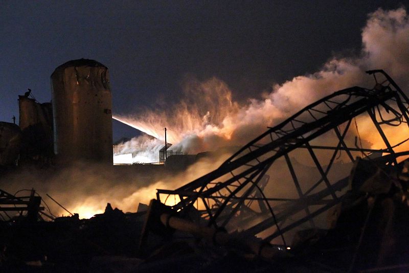 Los bomberos lanzaban agua a presión sobre los restos aún humeantes de la planta de fertilizantes