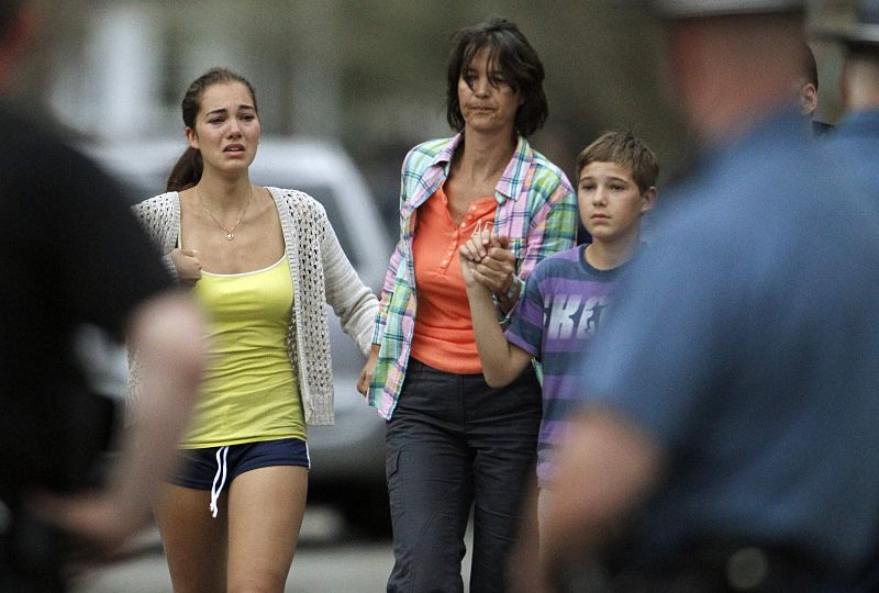 A family runs away from their house as police SWAT teams assault a house during the search for Dzhokhar Tsarnaev, suspect in Boston Marathon bombings, in Watertown