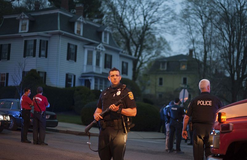 Police escort residents from their home as they move towards a police assault on a house on Franklin Street in Watertown