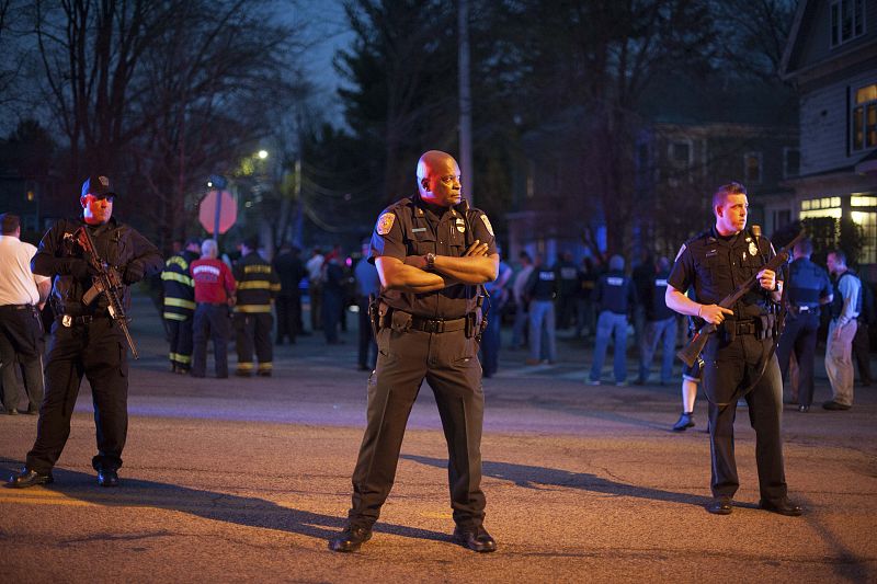 Police keep a close watch on a blocked-off street as they move towards a police assault on a house on Franklin Street in Watertown