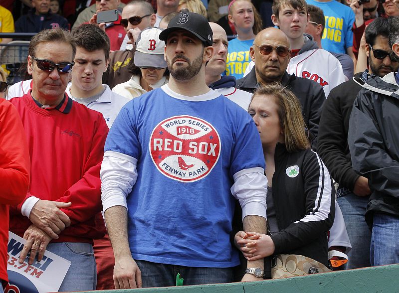 Baseball fans react during a moment of silence honoring the victims of the Boston Marathon bombings, before MLB American League baseball action in Boston