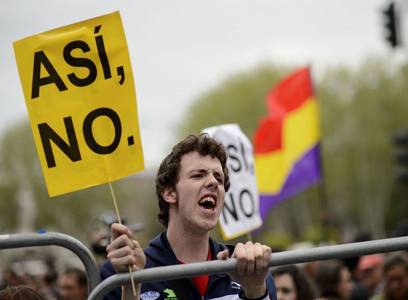 Un joven porta una pancarta en la que se puede leer el lema "Así, no".