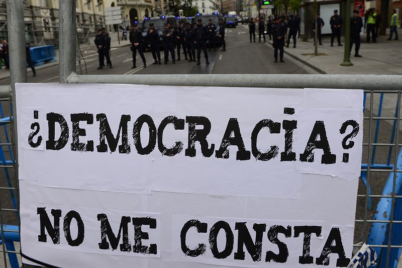 Uno de los carteles colgados de las vallas que blindan el Congreso: "¿Democracia? No me consta"