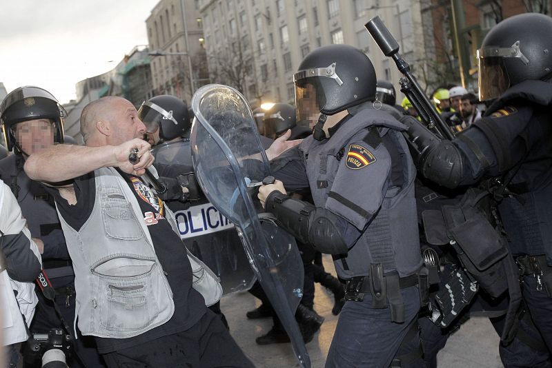 Un manifestante se enfrenta a varios miembros de la Policía Nacional en la plaza de Neptuno