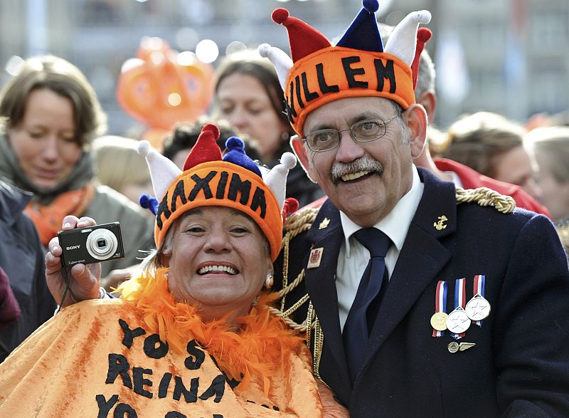 A couple waits for Queen Beatrix's abdication ceremony outside the Royal Palace in Amsterdam