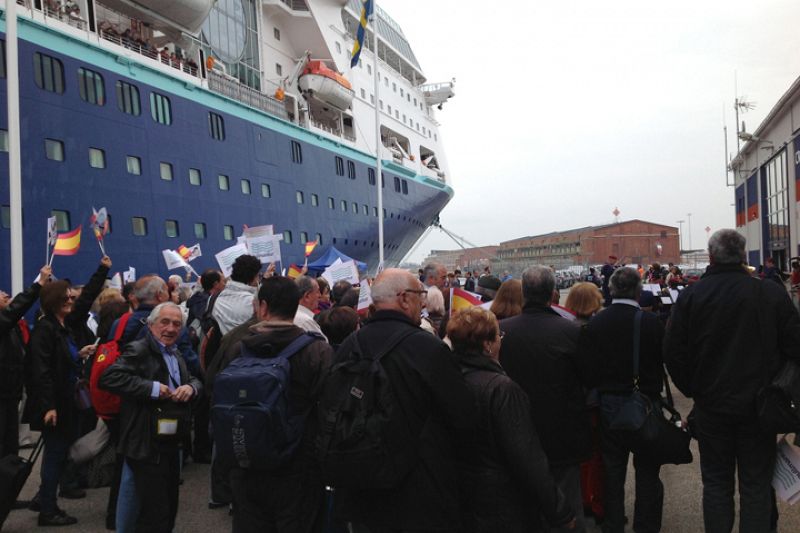 Fans y pasajeros del crucero esperan en el puerto a El Sueño de Morfeo. Banderas españolas, gritos de ánimo y música de Abba han amenizado la fiesta de bienvenida.