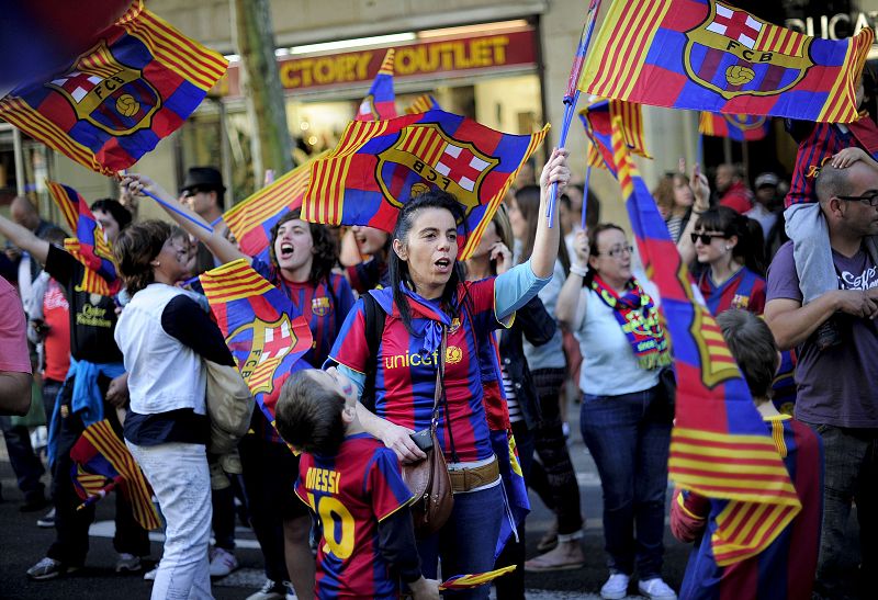 Aficionados del Barcelona con banderas en las calles de la ciudad condal