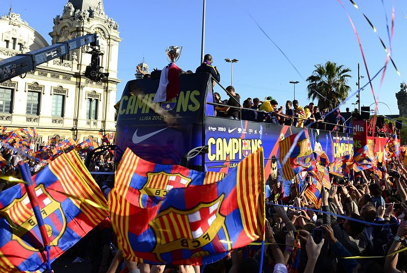 Jugadores del Barcelona recorren las calles de la ciudad entre banderas de los aficionados