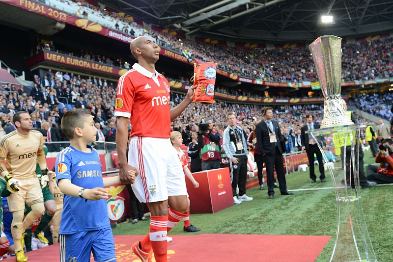 El defensa del Benfica Luisao Silva salta al campo al lado del trofeo de la Europa League