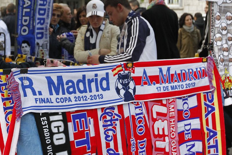 Un puesto de venta ambulante luce productos de los dos equipos