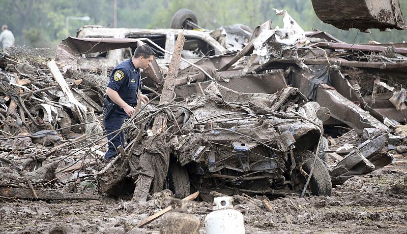 Un policía busca supervivientes en un coche que ha quedado sepultado tras el paso del tornado por Oklahoma