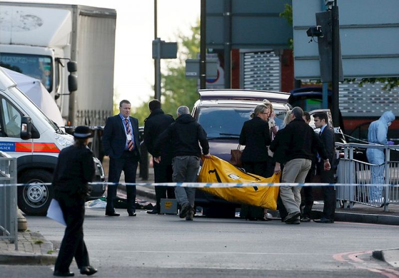 Policías forenses se llevan el cadáver del soldado muerto en Woolwich, en el sureste de Londres.