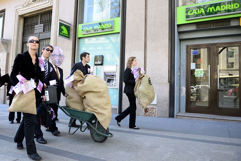 Una decena de manifestantes disfrazados de banqueros y encabezados por un supuesto Montoro se dirigen al Banco de España