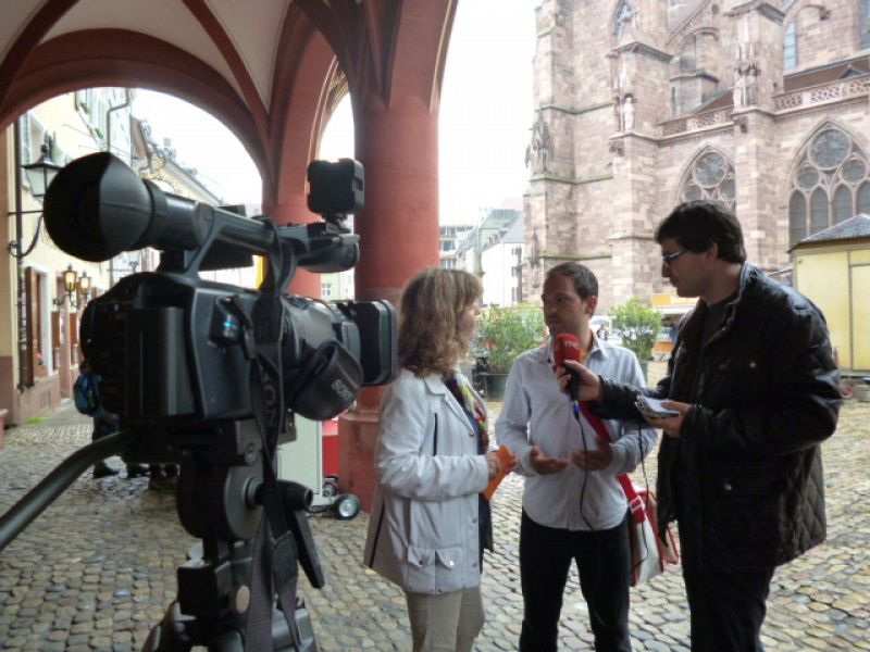 El guía de Friburgo Mirko Schneider atiende a Esther García Tierno y Álvaro Soto frente a la catedral de la ciudad