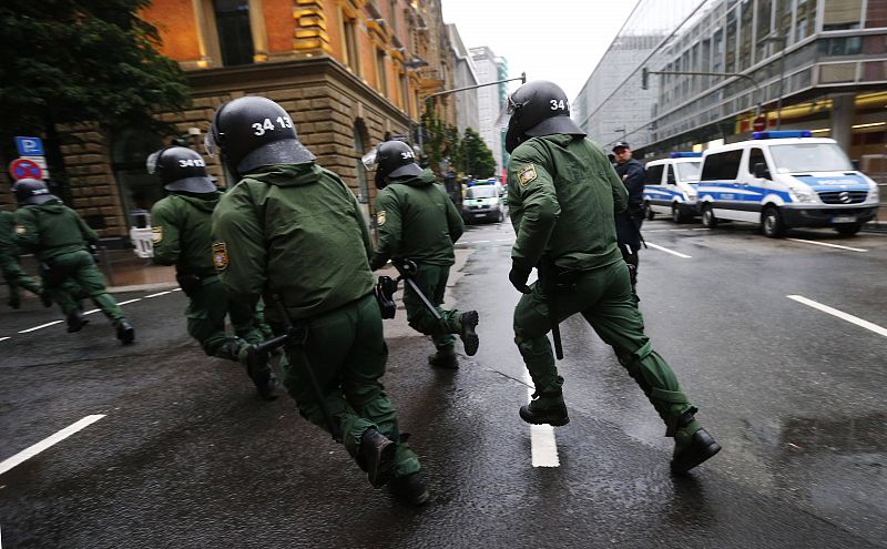 Policías antidisturbios corren por el barrio financiero de Frankfurt cerca de la sede del BCE