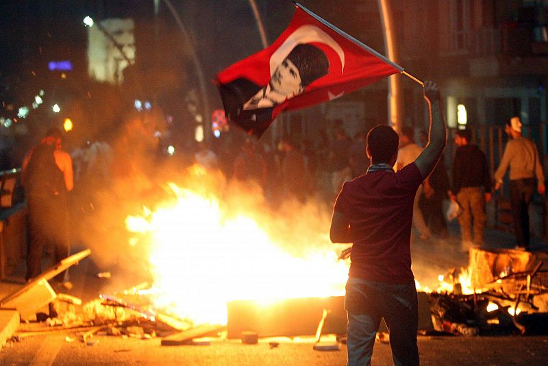 Un manifestante agita la bandera nacional con el retrato de Mustafa Kemal Ataturk, el fundador de la Turquía Moderna.