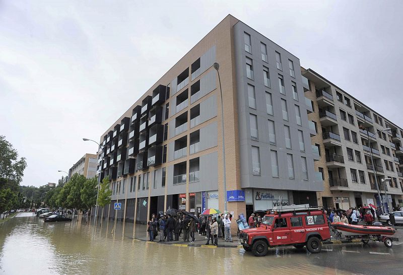 Bomberos trabajan en una calle inundada de Pamplona